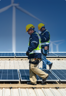 Image of workers on a roof walking alongside solar panels