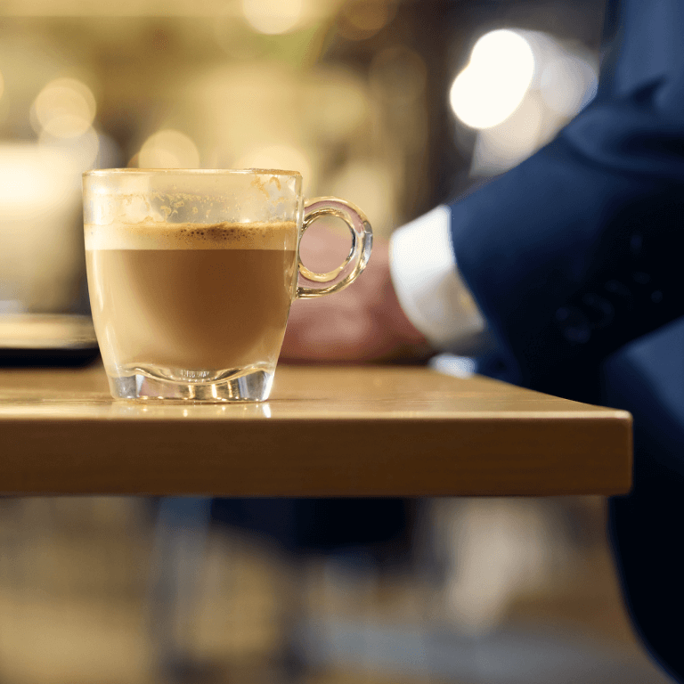 Image of a table with a coffee in a glass mug 