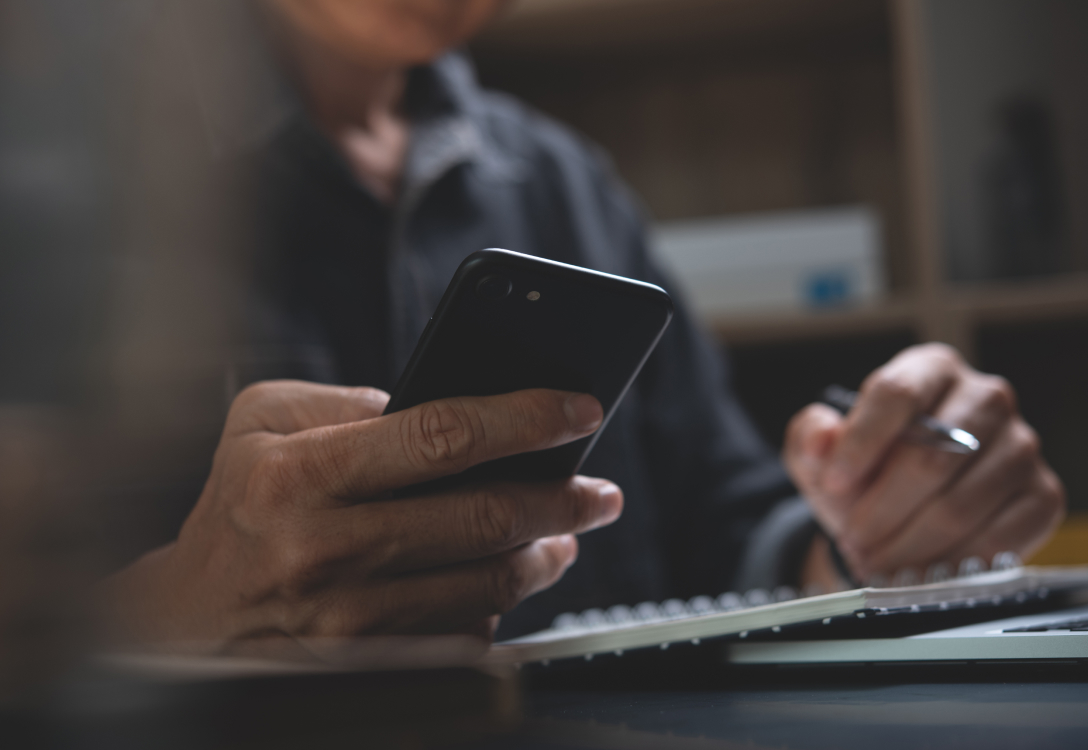 Image of a man holding his mobile phone while working