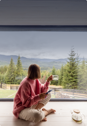 Image of a woman sitting and looking out a window with a cup of tea