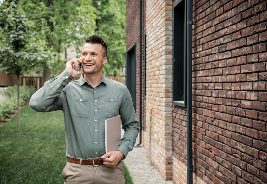 Image of a man outside a home on a phone call