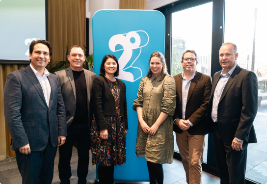 Members of the 2degrees team in front of the 2degrees logo