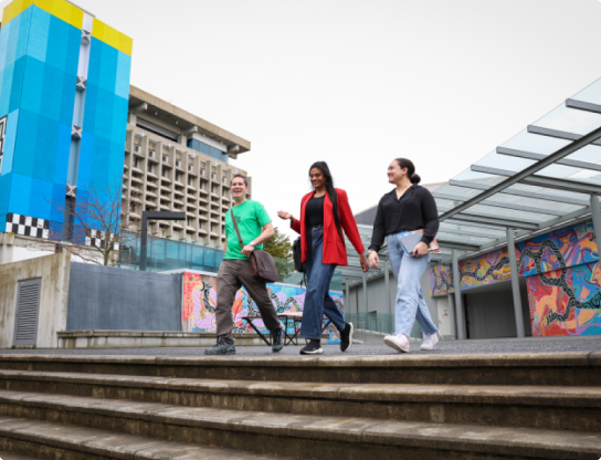 Photo of students leaving a university building and walking down stairs