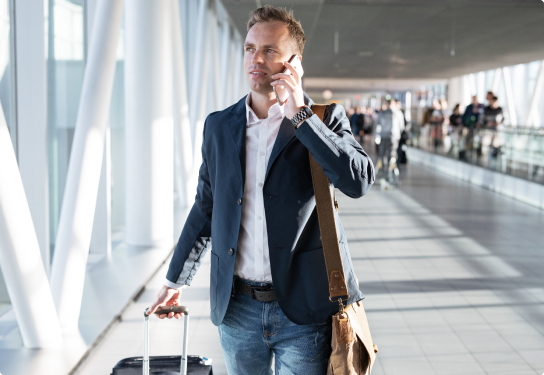 Image of a man on a phone call walking through an airport