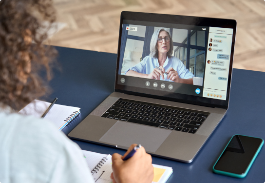 Image of a student attending an online class on her laptop with the lecturer on the screen and the team chat on the right