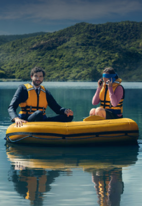 two people sitting in an inflatable dingy on a lake