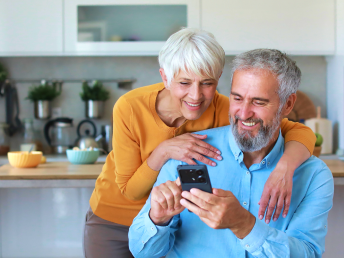 Image of a woman and a man looking at a mobile phone together