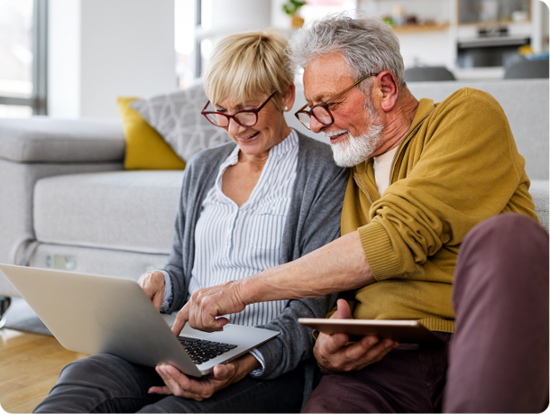 Couple working on a laptop and a tablet while sitting on the floor