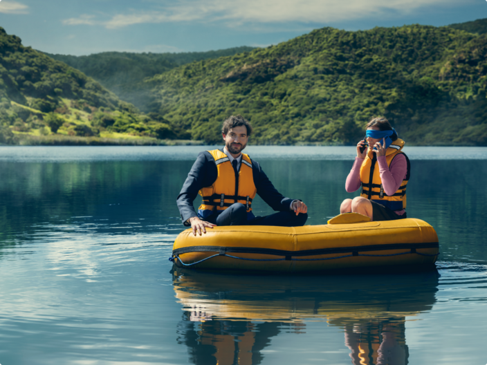 two people sitting in an inflatable dingy on a lake